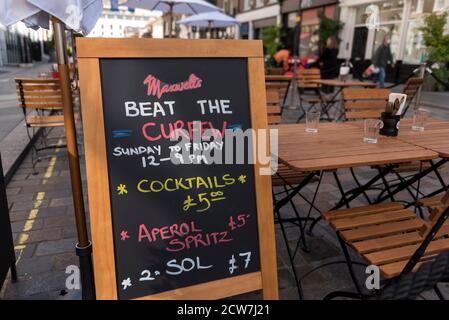 Londra, Regno Unito. 28 settembre 2020. Un cartello all'esterno di un bar a Covent Garden progettato per attrarre i clienti in seguito alla richiesta di chiusura di bar e pub alle 22:00 come parte delle restrizioni di blocco del coronavirus imposte dal governo britannico. Credit: Stephen Chung / Alamy Live News Foto Stock
