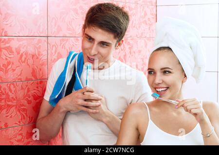 Una giovane coppia sta spazzolando i denti. La coppia si stolge in bagno. Fotografia lifestyle Foto Stock