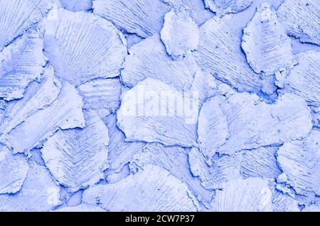 Lo sfondo è lilla. Disegno astratto in calcestruzzo. La superficie decorativa in forma di petali è realizzata in cemento. Motivo viola chiaro. Foto Stock