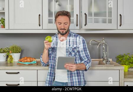 Uomo con mela e tablet digitale Foto Stock