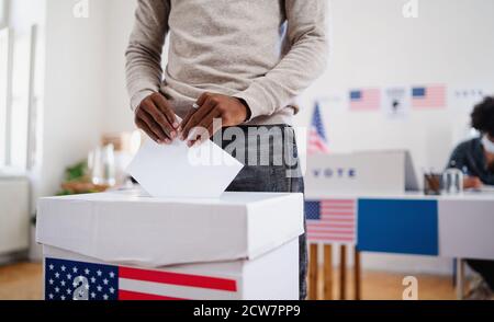 Irriconoscibile uomo afro-americano che ha messo il suo voto nel voto, elezioni usa e coronavirus. Foto Stock