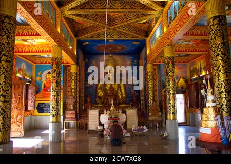 Interni dai colori brillanti della sala di ordinazione (Ubosot) presso il tempio buddista di Wat Phong Sunan, Phrae, nel nord della Thailandia Foto Stock