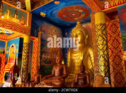 Interni dai colori brillanti della sala di ordinazione (Ubosot) presso il tempio buddista di Wat Phong Sunan, Phrae, nel nord della Thailandia Foto Stock