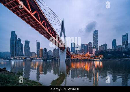 La vista notturna del ponte Qiansimen e dello skyline di Chongqing, Cina. Foto Stock
