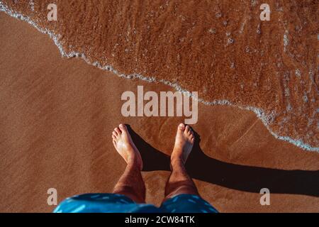 Le Mans i piedi in acqua chiara sulla spiaggia Foto Stock