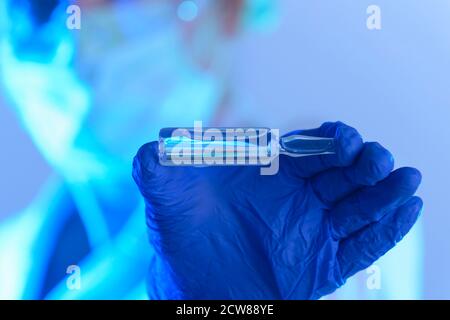 scienziato che lavora in un laboratorio che tiene una fiala con un nuovo farmaco antivirale Foto Stock