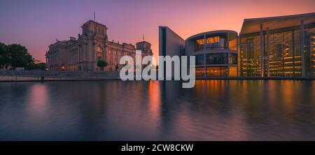 Tramonto lungo il fiume Sprea con vista verso il Reichstag Building e l'architettura moderna del Paul Loebe Building sulla destra, a Berl Foto Stock