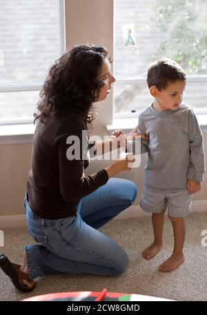 La mamma ispanica parla con il figlio arrabbiato di 4 anni a casa. Modello rilasciato ©Bob Daemmrich Foto Stock