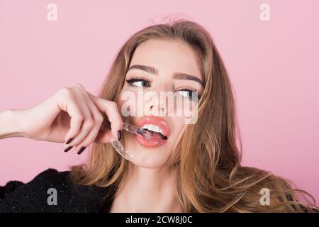 Fermo denti per migliorare il morso. Cura dei denti. La donna sostiene il dispositivo di bloccaggio dei denti. Apparecchio ortodontico mobile. Attrezzo di allineamento denti trasparente. Foto Stock