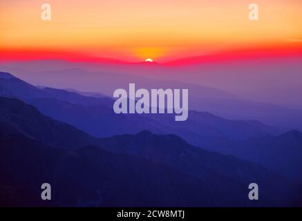 Maestoso paesaggio montano con sagome di creste di montagna al tramonto Foto Stock