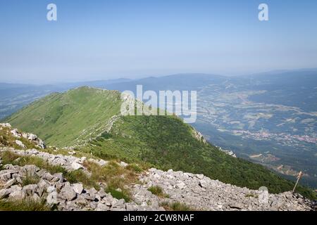 Vista dalla cima di Siljak sulla montagna di Rtanj di impressionante, stretta, cresta rocciosa di montagna e coperta da erba verde Foto Stock