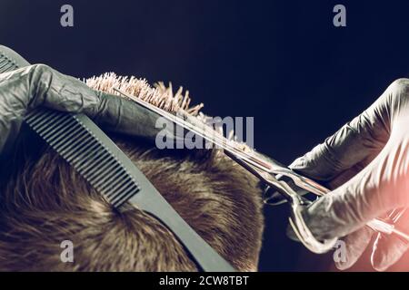 Taglio corto di capelli barbiere del cliente con forbici Foto Stock