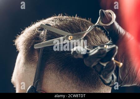 Taglio corto di capelli barbiere del cliente con forbici Foto Stock