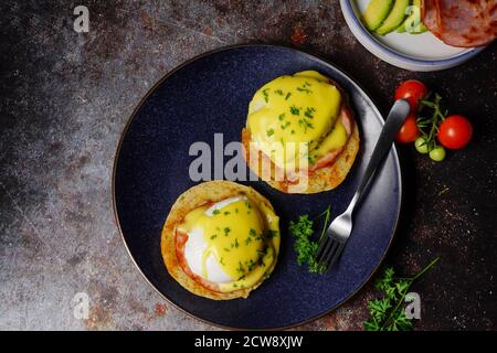 Uova Benedict fatte in casa con uova in camicia perfetta pancetta canadese condita con salsa Hollandaise, fuoco selettivo Foto Stock