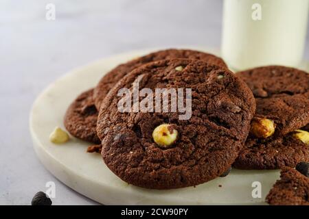 Biscotti a doppio chip di cioccolato e bicchiere di latte, fuoco selettivo Foto Stock