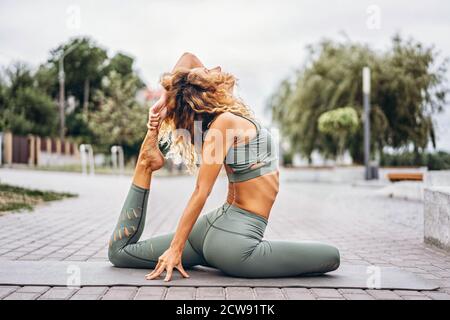 Immagini Stock - Giovane Donna Snella In Piedi Sul Tappetino Da Ginnastica  Allungando La Mano E La Gamba Durante L'allenamento Sportivo Vicino Al  Bordo Della Piscina All'aperto. Image 130502275