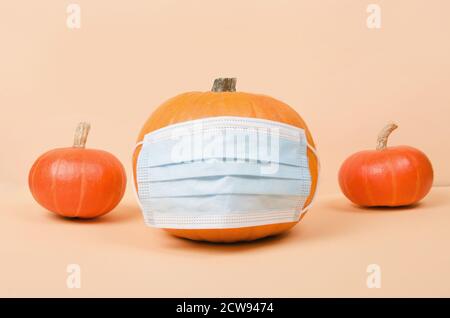 La zucca di Halloween arancione indossa una maschera medica protettiva. Concetto Covid-19 Foto Stock