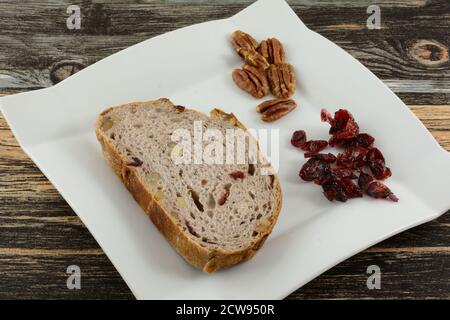 Fetta di pane di noce mirtillo con noci e mirtillo secco sul tavolo Foto Stock