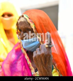 Beawar, Rajasthan, India, 28 settembre 2020: Un'anziana votatrice di donna Bardi Devi mostra il suo dito inchiodato dopo il voto del cast durante le elezioni di Panchayati Raj, in mezzo alla pandemia di coronavirus in corso, nel villaggio di Sendra vicino a Beawar. Oltre il 83.50 per cento degli elettori del 31.95-lakh hanno espresso i loro voti nella prima fase di 947 grammi Panchayat (Consiglio del Villaggio) elezioni in 25 distretti in tutto lo stato. Le linee guida relative al COVID-19 non sono state seguite durante le elezioni. Gli elettori indossano maschere facciali ma non hanno mantenuto la distanza sociale. Credit: Sumit Saraswat/Alamy Live News Foto Stock