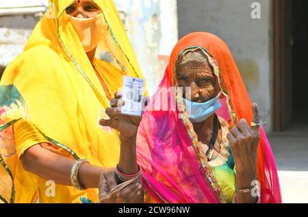 Beawar, Rajasthan, India, 28 settembre 2020: Un'anziana votatrice di donna Bardi Devi mostra il suo ID Voter e ha inked il dito dopo il voto del cast con la sua nuora durante le elezioni di Panchayati Raj, in mezzo alla pandemia di coronavirus in corso, nel villaggio di Sendra vicino a Beawar. Oltre il 83.50 per cento degli elettori del 31.95-lakh hanno espresso i loro voti nella prima fase di 947 grammi Panchayat (Consiglio del Villaggio) elezioni in 25 distretti in tutto lo stato. Le linee guida relative al COVID-19 non sono state seguite durante le elezioni. Gli elettori indossano maschere facciali ma non hanno mantenuto la distanza sociale. Credit: Sumit Saraswat/Alamy Live News Foto Stock