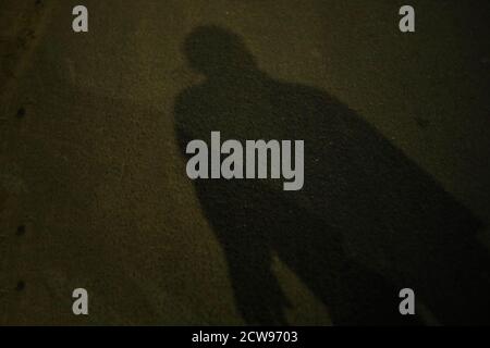 Ombra sfocata e silhouette di un uomo in piedi in notti Foto Stock
