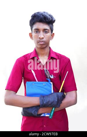 meccanico in uniforme con braccia incrociate e utensili di tenuta, isolato su sfondo bianco Foto Stock