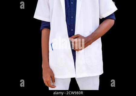 Ritratto troncato di un giovane medico maschile con le mani in mano camice bianco su sfondo nero Foto Stock