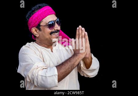 Sorridente indiano che tiene la mano nel gesto di namaste, Foto Stock