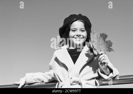 Idee per il tempo libero d'autunno. Bambina adorare la stagione autunnale. Kid tenere foglie di acero. Piccola ragazza indossare abbigliamento cadere all'esterno. Autunno lista della benna per bambini. Cielo chiaro e di buon tempo. Ispirando caduta. Foto Stock