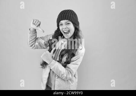 Il mio capo di abbigliamento Preferito. Pronto per l'inverno freddo. Clima freddo. Felice bambina rosa sfondo. Giacca piumino e cappello a maglia per bambini. Shopping invernale. Come vestirsi caldo in inverno. Foto Stock