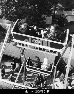 Le ragazze sorridenti guardano indietro al fotografo mentre cavalcano la ruota panoramica in una fiera della contea, Lancaster, OH, 1949. (Foto di United States Information Agency/RBM Vintage Images) Foto Stock