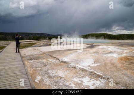 Wyoming, USA - 1 luglio 2020: L'uomo del turismo scatta le foto di una caratteristica geotermica di sorgente calda nel parco nazionale di Yellowstone Foto Stock