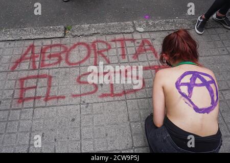 Bogotà, Colombia. 27 Settembre 2020. Una donna spray ''interrompere il sistema'' sul pavimento. Di fronte alla Corte Suprema della Colombia, dove si sono incontrati per dimostrare la legalizzazione degli aborti nel paese, una parte della protesta era quella di coprire con vernice verde un graffito precedente fatto da sostenitori non aborti. Credit: Daniel Garzon Herazo/ZUMA Wire/Alamy Live News Foto Stock