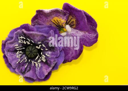 feltro fatto a mano, fiori, due fiori viola su sfondo giallo Foto Stock