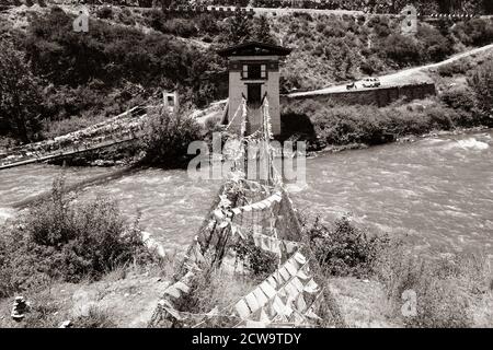 Ponte sospeso in catena di ferro vicino a Tachogang Lhakhang a Paro, Bhutan Foto Stock