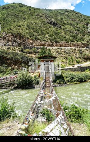 Ponte sospeso in catena di ferro vicino a Tachogang Lhakhang a Paro, Bhutan Foto Stock