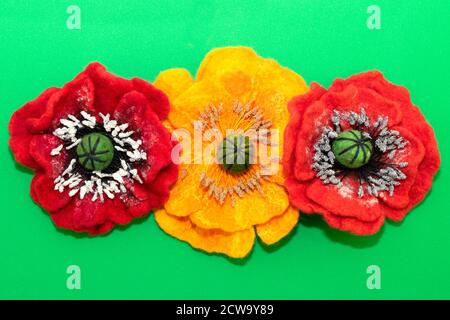 feltro fatto a mano, fiori, tre fiori di feltro su sfondo verde Foto Stock