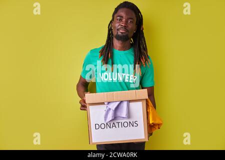 ritratto di uomo volontario afro nero con scatola piena di vestiti, giovane  maschio con dreadlock impegnati nella carità, amore aiutare gli altri Foto  stock - Alamy