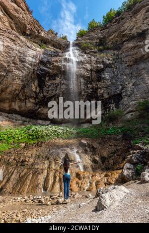 Ragazza turistica ammira la cascata Foto Stock