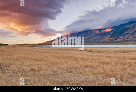 Enorme nuvola di fronte a Steens Mountain, che sorge a 5,000 metri sopra il lago Mann, all'alba, Alvord Desert, parte del Great Basin Desert, Oregon, USA Foto Stock