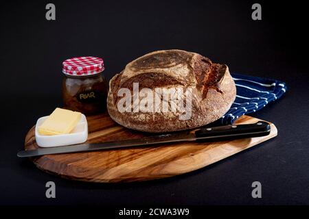 Pane di segale su una tavola di legno con fondo nero Foto Stock