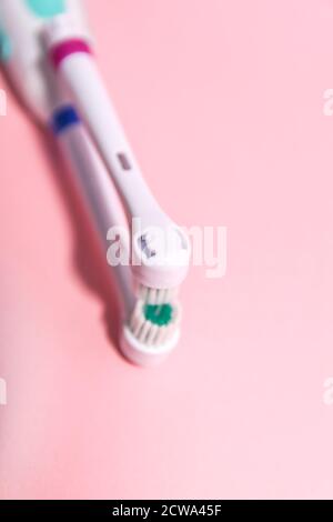 Due spazzolini elettrici su uno sfondo rosa chiaro e morbido. Foto Stock