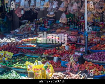 Enormi banane arancioni appendono su una bancarella di mercato in una piccola città sull'isola di Ambon, Maluku, Indonesia. Asia Foto Stock