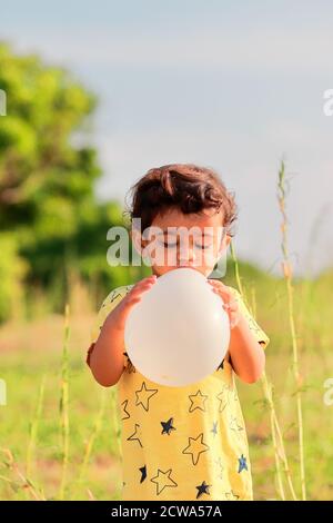 Ritratto un ragazzo indiano versa aria nel pallone Foto Stock