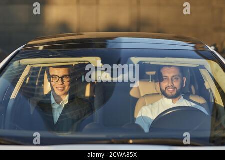 Ritratto di una coppia che sorride alla fotocamera mentre si è seduti nella auto e guida Foto Stock