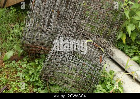 Rotoli di rete metallica per recinzioni giacciono nel giardino Foto Stock