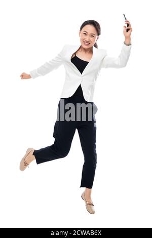 Tenere un telefono cellulare eccitante donna di affari Foto Stock