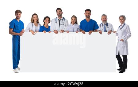 Gruppo di felici medici multirazziali che tengono un cartello bianco con copia spazio per testo isolato su sfondo bianco verticale a lunghezza intera Foto Stock