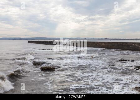 Vista del mare in tempesta a Hartlepool Headland con industriale Teesside in background Foto Stock