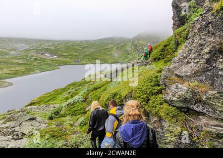 Escursionisti sulla cascata di Hydnefossen e sul fiume Hydna sul monte Veslehødn Veslehorn a Hemsedal, Norvegia. Foto Stock